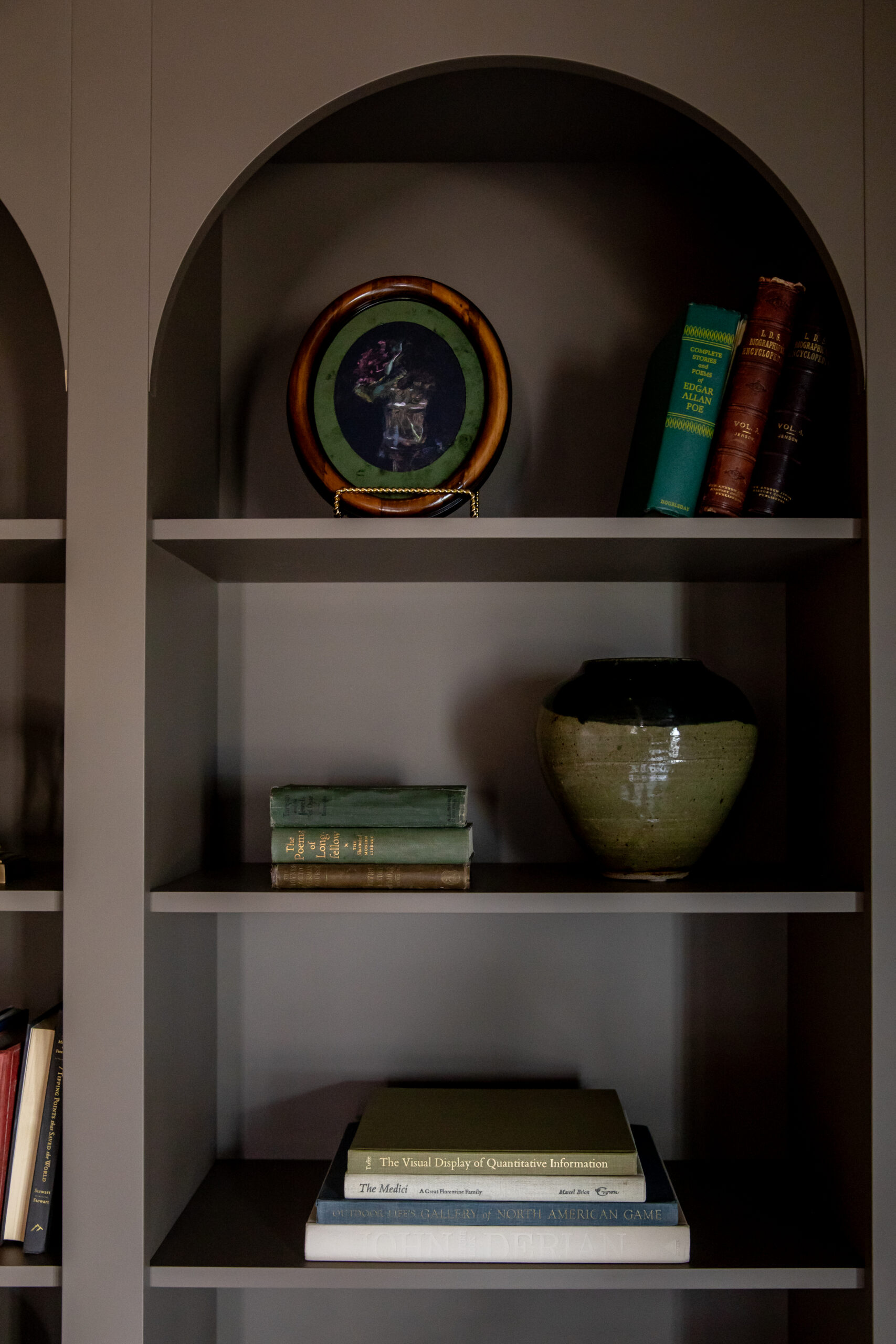 Custom arched built-in shelving with curated decor and moody millwork in a luxury Utah home