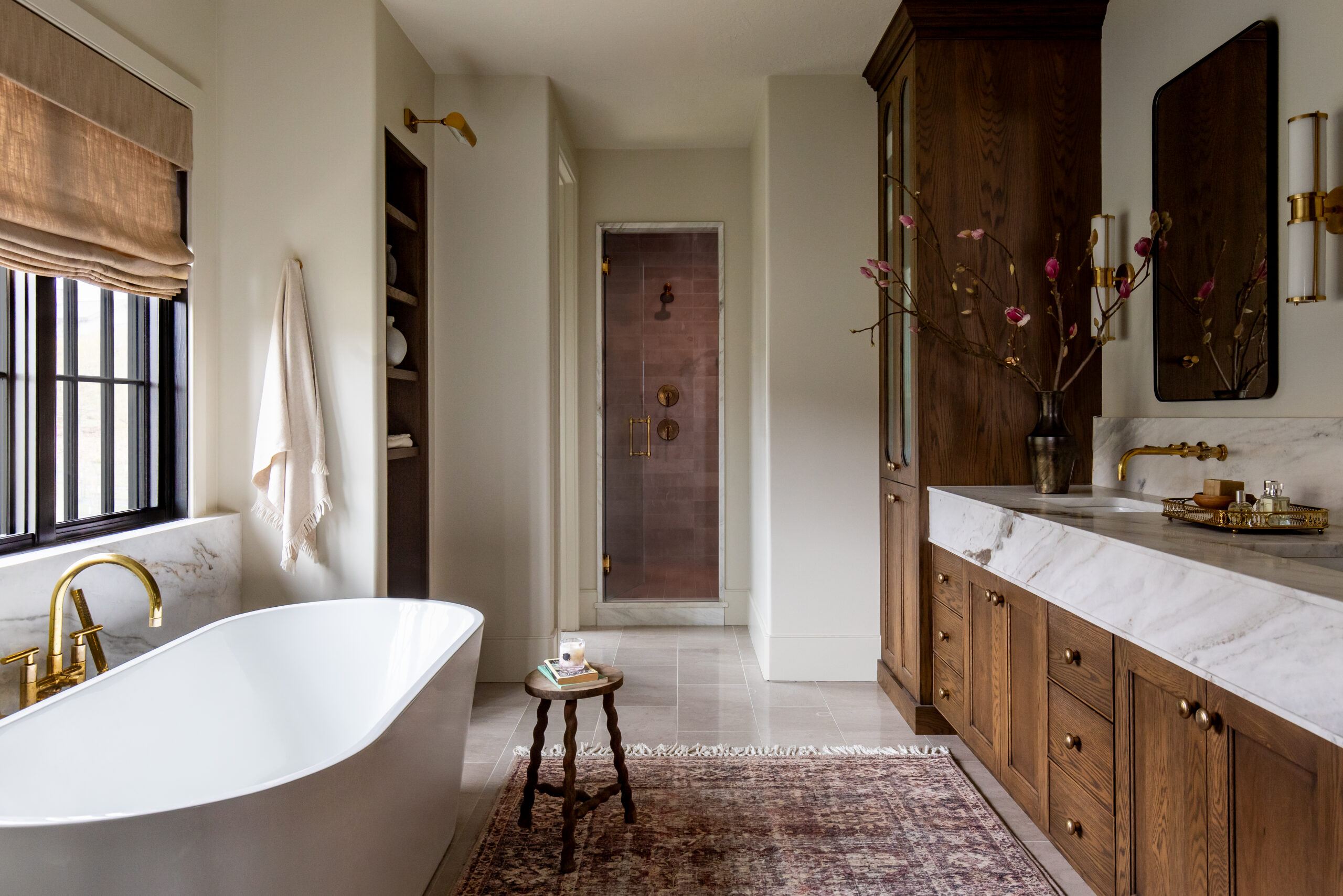 Luxury primary bathroom with freestanding soaking tub, marble vanity, and custom wood cabinetry in a Utah custom home