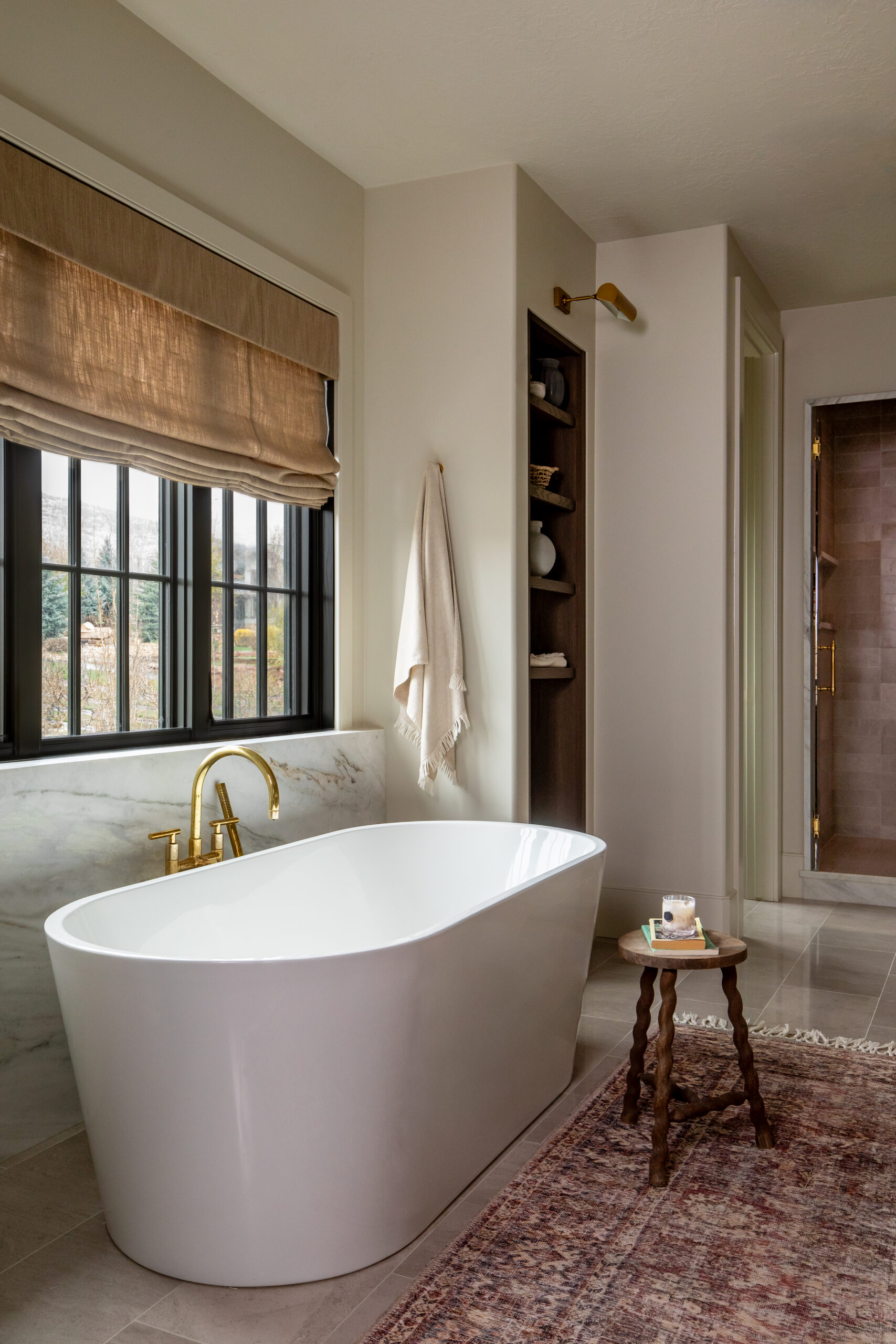 Luxury freestanding soaking tub with brass fixtures and marble surround in a custom Utah bathroom