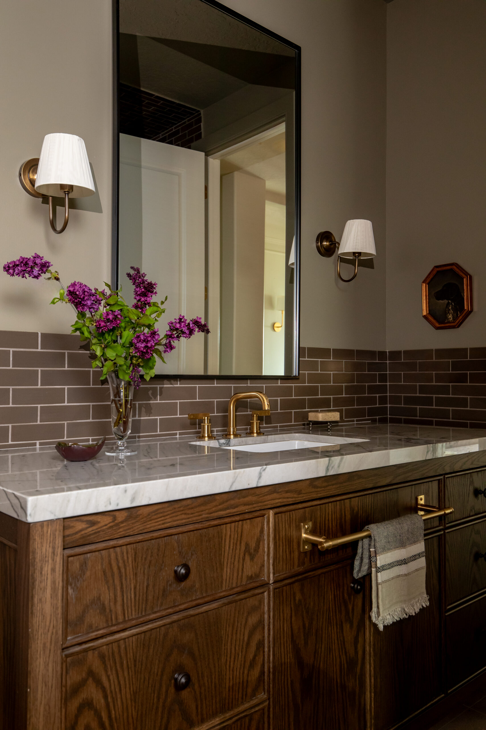 Luxury bathroom vanity with dark wood cabinetry, brass fixtures, and marble countertop in a Utah custom home